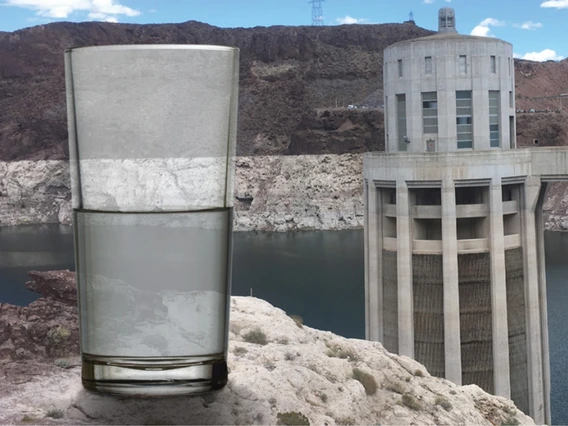 half glass of water in front of the hoover dam