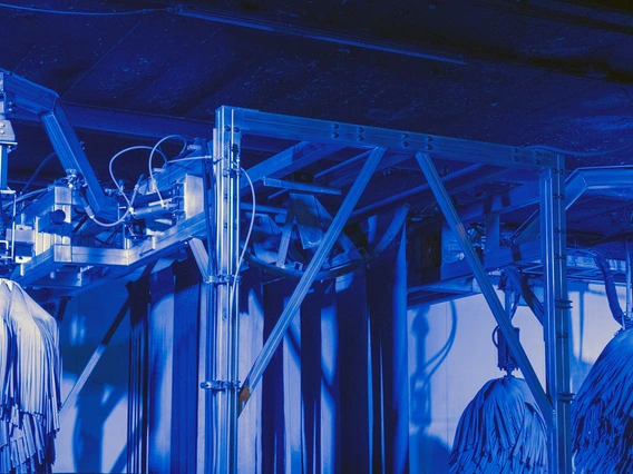 a photo showing a carwash in action. it has a blue cast.