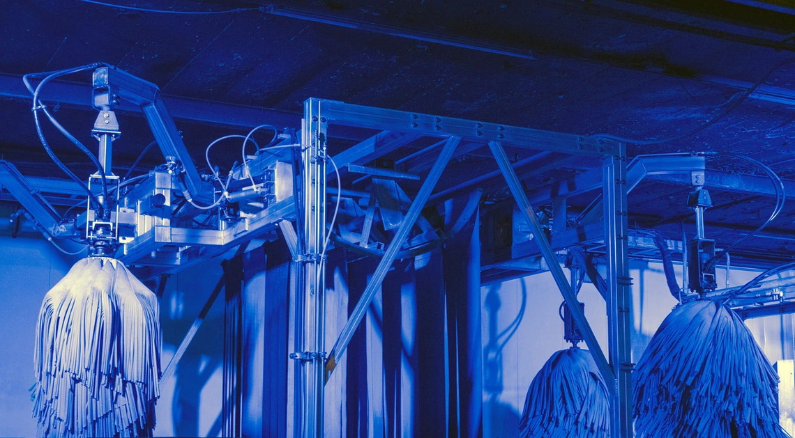 a photo showing a carwash in action. it has a blue cast.