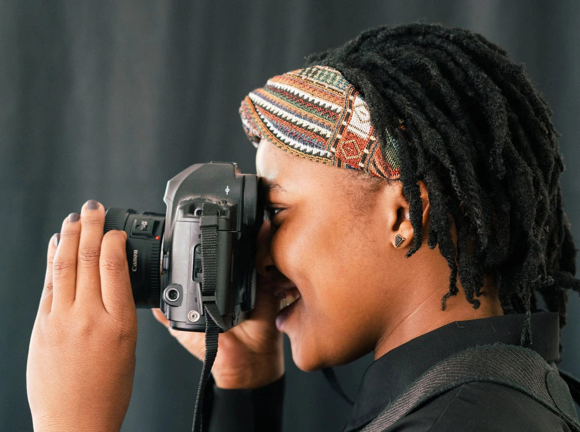 An individual focusing a camera An individual focusing a camera