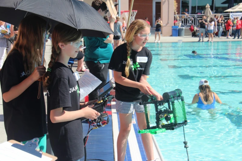 students by pool with robots students by pool with robots