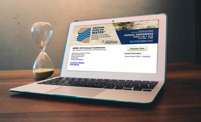 laptop displaying details for 2019 conference next to an hourglass laptop displaying details for 2019 conference next to an hourglass