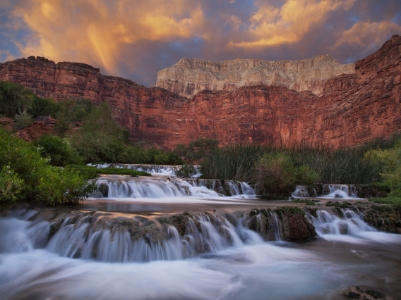 Dave Wilson photo showing motion in water at Havasu Creek; Grand canyon, AZ with red rocks in the background