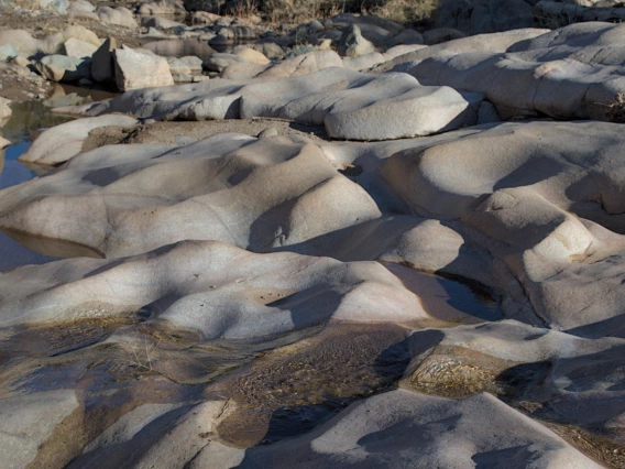 dune like rock formation with water flowing through it and on it