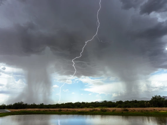 a body of water with rainclouds and lightning