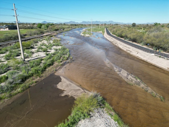 photo showing the Rillito-Pantano Confluence. grean plants on the banks and blue sky