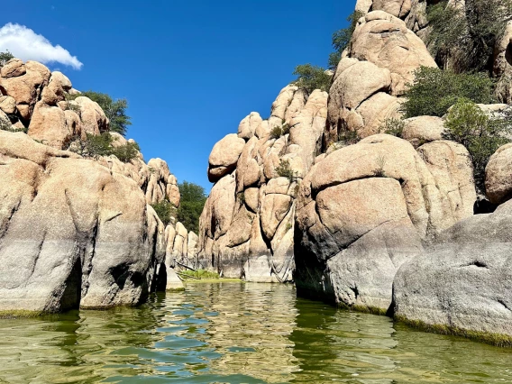 Paddleboarding Watson Lake - perspective of paddleboarder. rocky canyon walls, green water, and blue sky with few white clouds