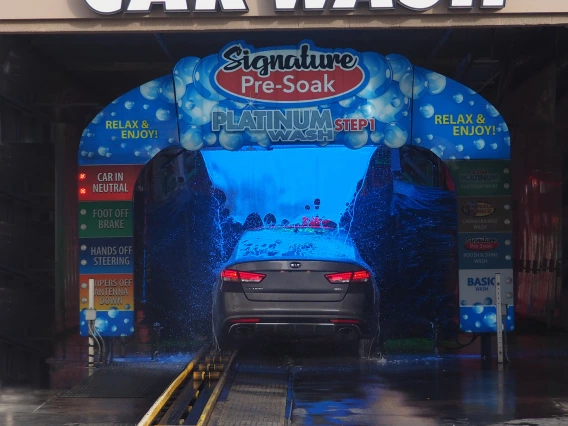 colorful photo a a car going through a carwash. Inside has a blue cast