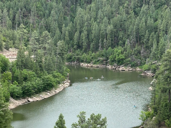 photo of blue ridge reservoir showing people engaged in water activites. green pine trees surround