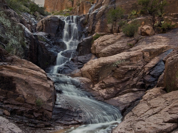 moody, cloudy photo of canyon water falls in the superstition mts