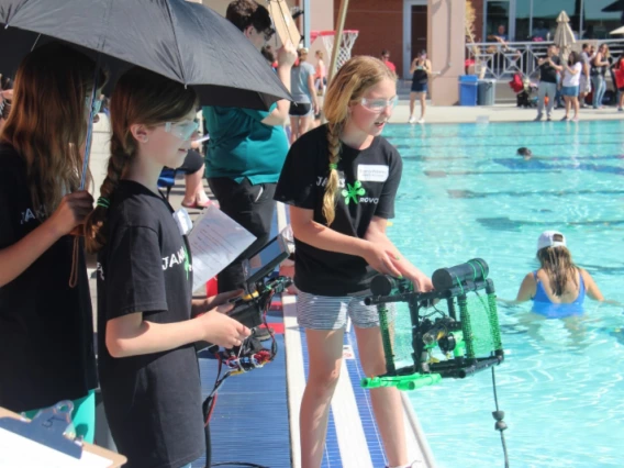 students  by pool with robots