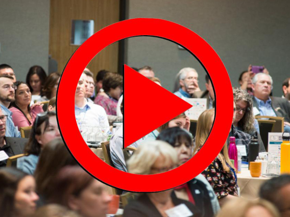 2019 Annual Conference Audience with a red play button overlaid