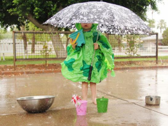 girl holding umbrella and collecting water