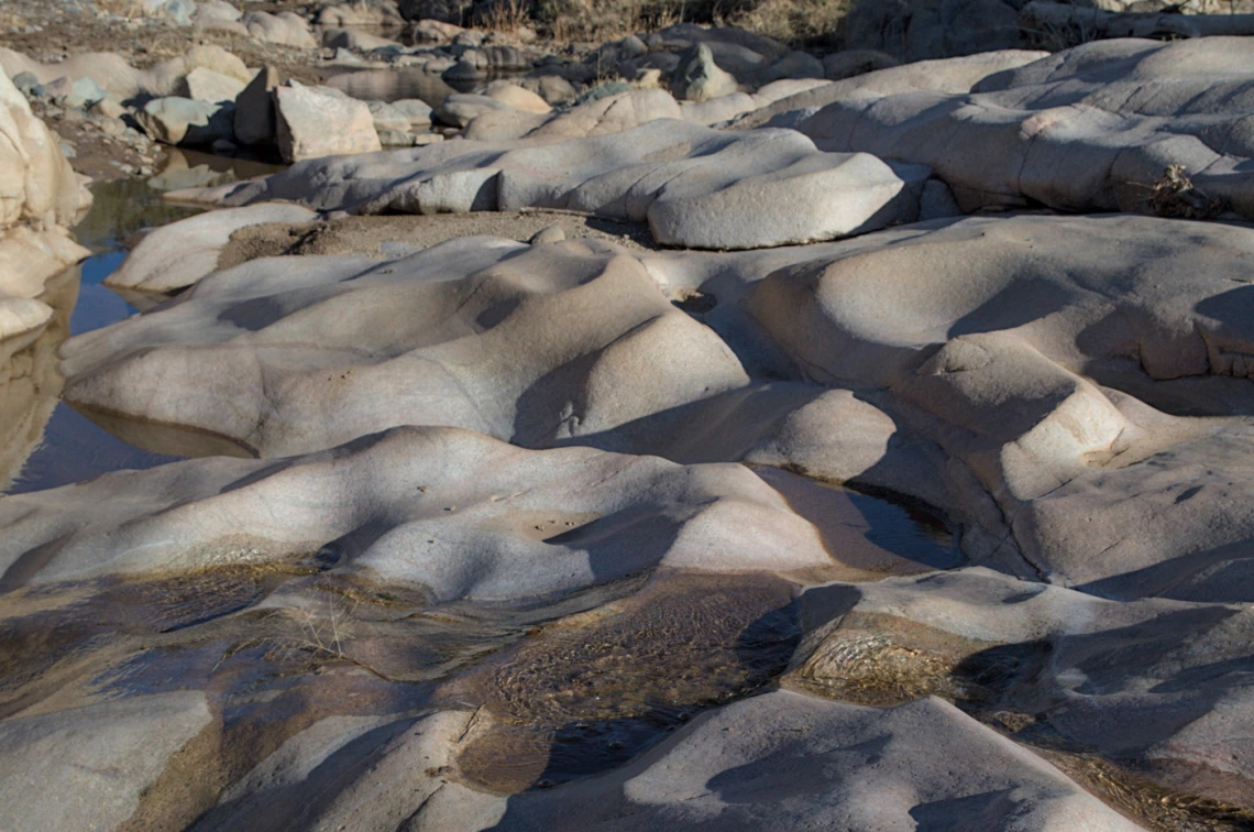 dune like rock formation with water flowing through it and on it