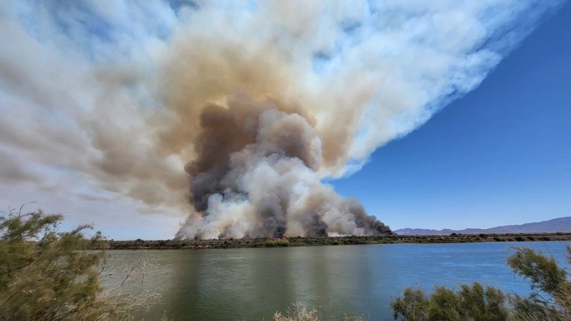 photo of a fire on the edge of a lake