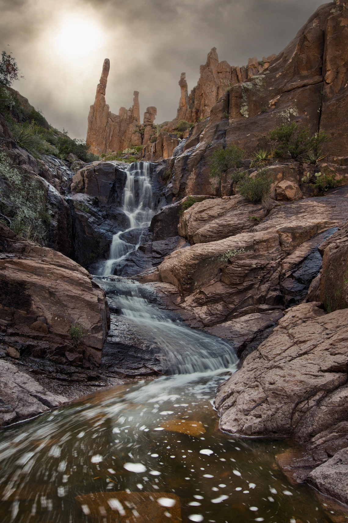 moody, cloudy photo of canyon water falls in the superstition mts