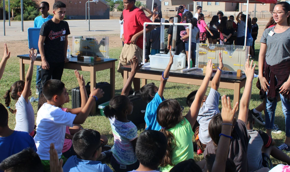 students raising hands to ask questions in an apw event