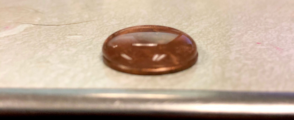 penny covered with water droplets