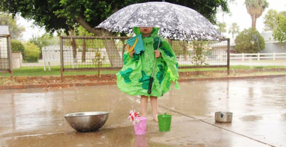 girl holding umbrella and collecting water
