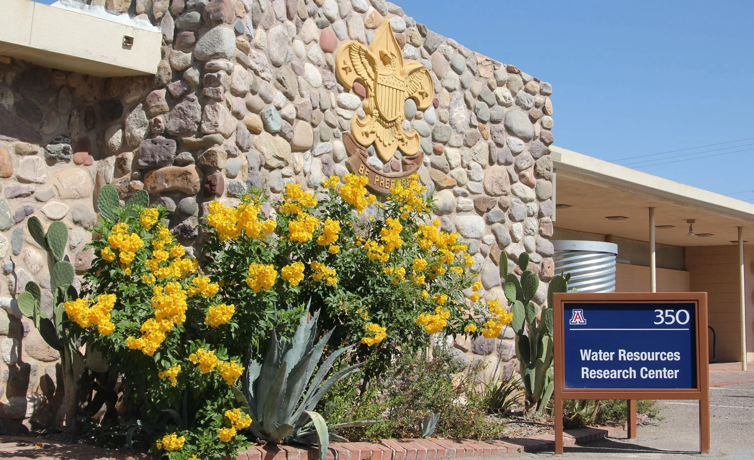 photo of the front of the WRRC featuring a blue sign and yellow flowers