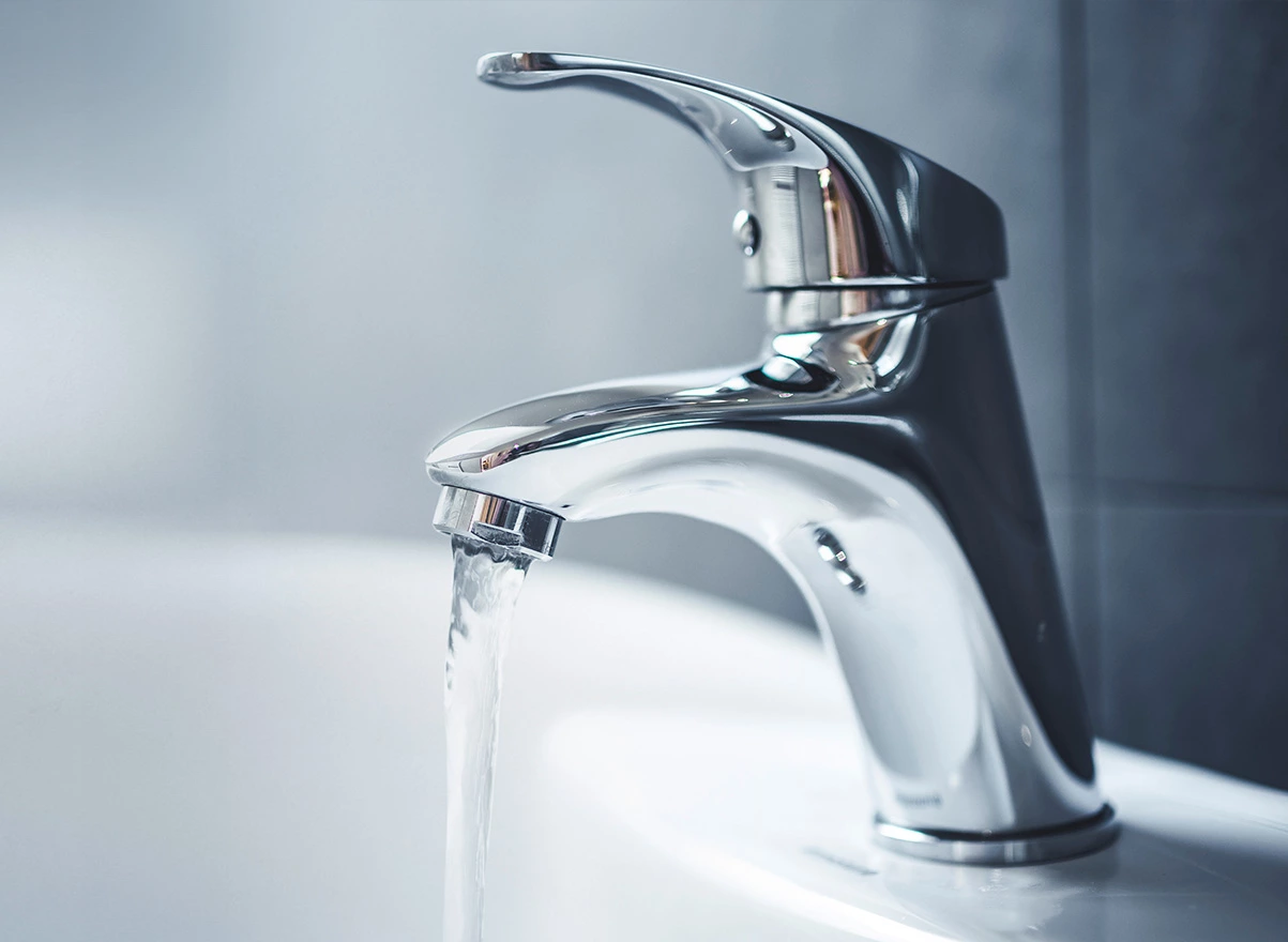 cropped photo of a faucet with water running