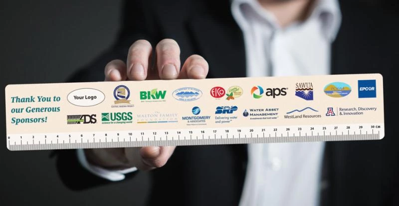 a hand holding a ruler with sponsor logos